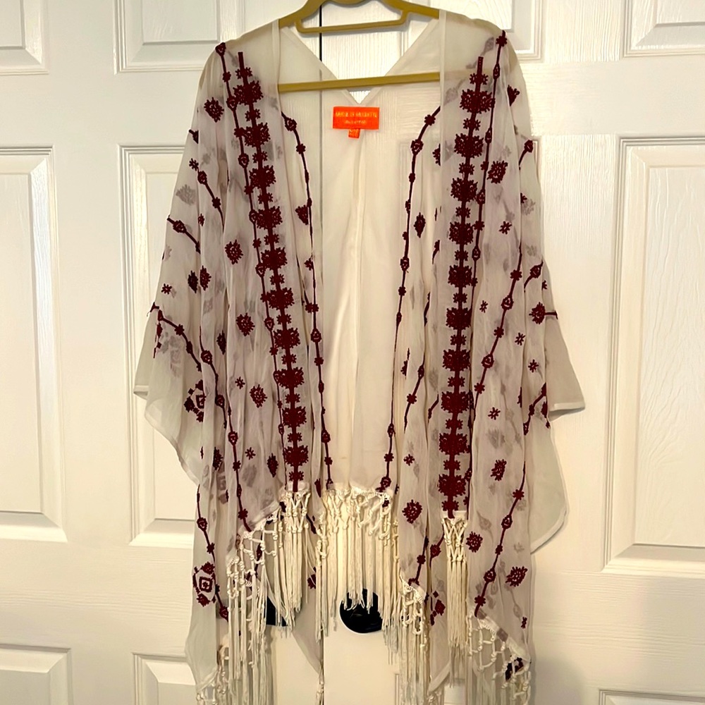 One size fits all cream with maroon designs and fringe bottom